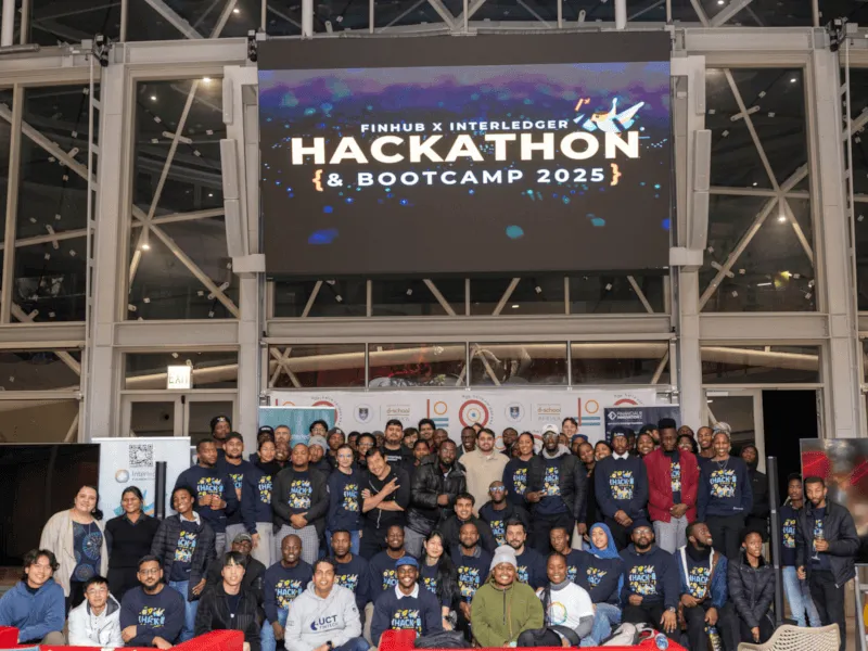 Group photo of all hackathon participants standing on stage at the UCT Financial Innovation Hub.